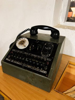 Khodakhkiv, Ukrayna - 29 Kasım 2025: Eski yeşil alan telefonu ahşap masada çevirmeli, düğmeli ve sarmalanmış kabloyla.