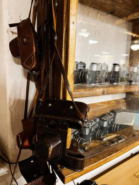 Khodakhkiv, Ukrayna - 29 Kasım 2025: Ahşap bir dolapta eski film kameraları, deri çantalar ve antika teçhizatlar sergileniyor.