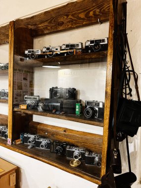 Khodakhkiv, Ukrayna - 29 Kasım 2025: Ahşap raflarda antika kameraların sergilenmesi, film ekipmanları ve retro fotoğrafçılık.