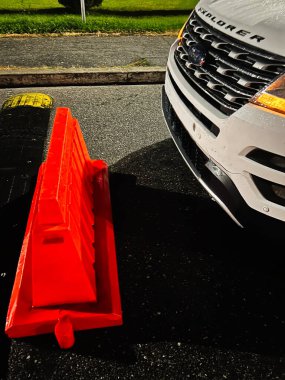 Nyzhankovychi, Ukrayna - 29 Kasım 2025: Güneşli bir otoparktaki turuncu bariyerin yanında beyaz Ford Explorer.