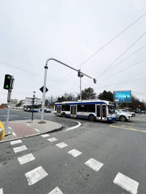 Chisinau, Moldova - 29 Kasım 2025: Moldova 'nın Chisinau kentindeki bulutlu gökyüzünün altında yoğun bir kavşakta tramvay ve otobüs sahnesi.