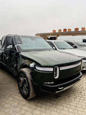 Kyiv, Ukrayna - 29 Kasım 2025: Yeşil bir Rivian R1T SUV yan tarafında ağır hasar olduğunu gösteriyor.
