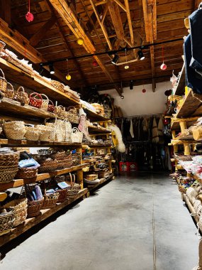 Khodakhkiv, Ukrayna - 29 Kasım 2025: Sıcak ışık altında dokuma sepetleri, kumaşlar ve şenlik dekorlarıyla dolu antika bir dükkan.