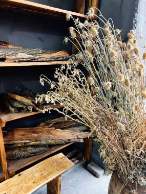 Kurumuş buket ve ahşap raflar hoş, sade bir vignette oluşturur..