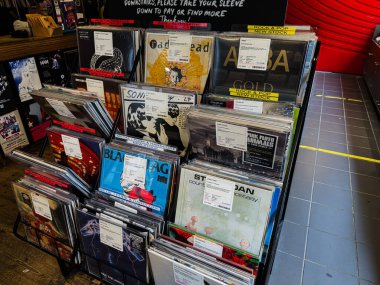 Manchester, İngiltere - 21 Ocak 2026: Bir müzik mağazasının duvarında çeşitli albüm sanat eserleriyle etiketlenmiş renkli vinil plaklar.