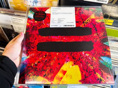 Manchester, İngiltere - 21 Ocak 2026: Ed Sheeran Equals siyah sansür çubukları ile canlı kırmızı sıçrama tasarımı içeren vinil albüm kapağı.