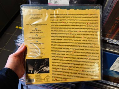 Manchester, İngiltere - 21 Ocak 2026: Şarkı listeleri ve Pharoah Sanders hakkında betimleyici metinlerin yer aldığı sarı vinil arka kapağa yakından bakın