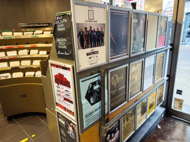 Manchester, İngiltere - 21 Ocak 2026: Meşgul bir şehir galerisindeki rafta bir sıra çerçevelenmiş poster ve el ilanı