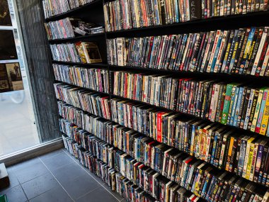 Manchester, İngiltere - 21 Ocak 2026: Karanlık raflardaki organize DVD ve Blu Ray film çantalarından oluşan bir duvar.