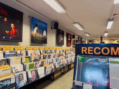 Manchester, İngiltere - 21 Ocak 2026: Vinyllerin, duvar posterlerinin ve organize müzik raflarının yer aldığı işlek bir plak mağazası sahnesi.