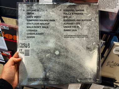 Manchester, İngiltere - 21 Ocak 2026: Bir müzik mağazasında vinil arka kapak, pist listesi ve eski model tasarımı gösteriliyor. Aylaklar Çalarken Yakalandı