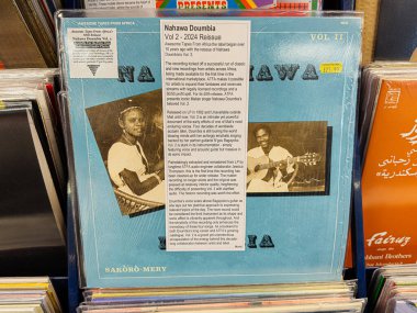 Manchester, İngiltere - 21 Ocak 2026: Afrika müzik plağı kapağı kadın gitarist ve şarkıcının mavi sanat çalışması; Mali tarzı dünya müziği atmosferi. Nahawa Doumbia Vol 2 2024 Yeniden Yayın