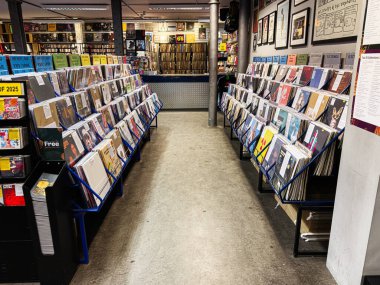 Manchester, İngiltere - 21 Ocak 2026: Vinil rafları ve posterlerle dolu işlek bir plak dükkanı ikonik bir müzik alışveriş ortamı yaratıyor.