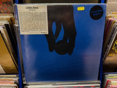 Manchester, İngiltere - 21 Ocak 2026: Mavi vinil kapak Little Simz Drop 6 hip hop için mavi arka planda siyah bir siluet barındırıyor.