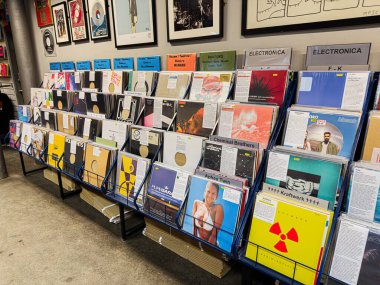 Manchester, İngiltere - 21 Ocak 2026: Vinil rafların ve duvarların geniş görünümü çeşitli müzik stilleri ve hatıra eşyaları sergiliyor.