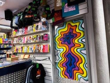 Manchester, İngiltere - 21 Ocak 2026: Renkli psikedelik kapı duvar resmi dergi rafları ve renkli ürünlerle dolu bir müzik mağazasında.