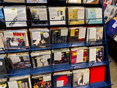 Manchester, İngiltere - 21 Ocak 2026: İşlek bir dükkanda görülen mavi bir rafta, kollarda ve fiyat etiketlerinde renkli vinil plaklar.