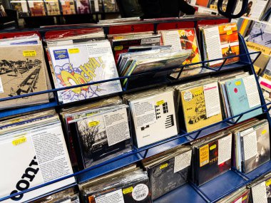 Manchester, İngiltere - 21 Ocak 2026: Vinil kollu, çeşitli müzik stilleri ve sanat eserleriyle dolu işlek bir plak dükkanı.