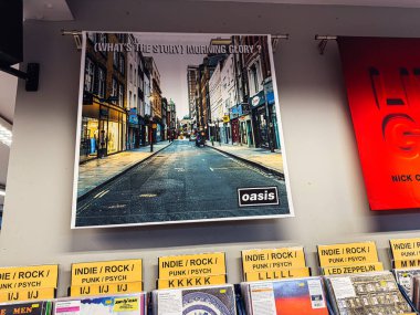 Manchester, İngiltere - 21 Ocak 2026: Oasis posterli canlı şehir sokağı, mağazalarda kentsel stil ve müzik enerjisi yakalıyor.