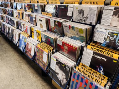Manchester, İngiltere - 21 Ocak 2026: Meşgul bir mağazada, renkli albüm sanatı ve organize çöp kutularında satılan viniller nostaljik bir müzik sahnesi oluşturdu.