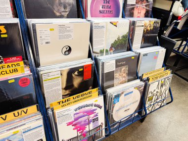 Manchester, İngiltere - 21 Ocak 2026: Renkli albüm kapakları ve etiketleri, müzik kültürü ve koleksiyon titreşimleri içeren canlı bir vinil plak rafı.