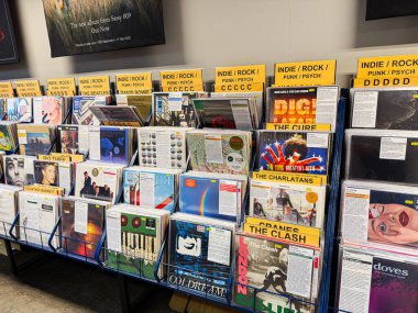 Manchester, İngiltere - 21 Ocak 2026: Sarı kategori tabelaları ve renkli plaklar ve albümlerle dolu canlı bir vinil ekran.