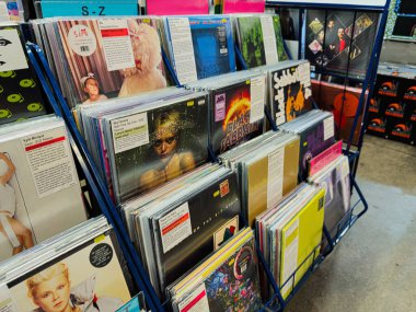 Manchester, İngiltere - 21 Ocak 2026: Vinil kollar ve fiyat etiketleriyle dolu işlek bir plak mağazası rafı, retro müzik ortamı yaratıyor.