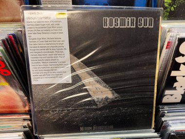 Manchester, İngiltere - 21 Ocak 2026: Kosmik Sun sanat eserleri, yıldızlar arası tema ve parlak bir çıkartma içeren siyah vinil albüm kapağı.