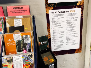 Manchester, İngiltere - 21 Ocak 2026: Renkli vinil kollu sıradan müzik mağazası sahnesi ve geniş bir Top 30 Koleksiyonu 2025 posteri.