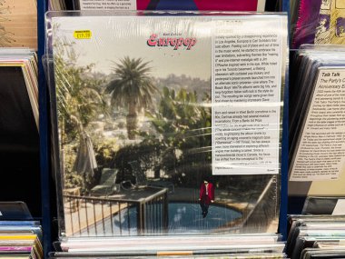 Manchester, İngiltere - 21 Ocak 2026: Carl Schilde Europop, palmiye ağaçları ve metin panellerinin yer aldığı güneşli havuz kenarı kapağı.