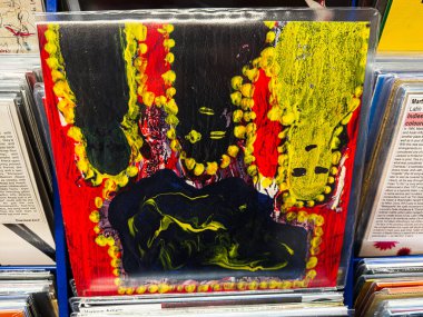 Manchester, İngiltere - 21 Ocak 2026: Karanlık bir merkezin etrafında parlak sarı boncuklarla çevrili kalın renkler tasarım, dinamik ve anlamlı.