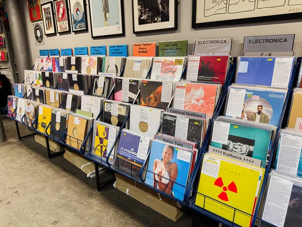 Manchester, İngiltere - 21 Ocak 2026: Vinil rafların ve duvarların geniş görünümü çeşitli müzik stilleri ve hatıra eşyaları sergiliyor.