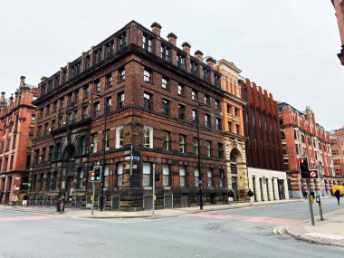 Manchester, İngiltere - 26 Ocak 2026: Tarihsel kırmızı tuğla binalar Manchester Lever caddesi hizasında, klasik şehir mimarisi ve şehir hayatı sergileniyor.