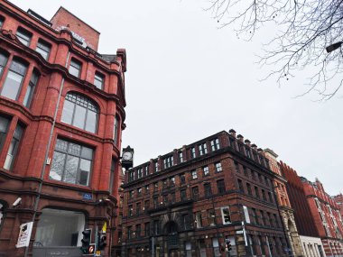 Manchester, İngiltere - 26 Ocak 2026: Manchester 'da Dale caddesi boyunca bir saat ve bulutlu gökyüzü içeren kırmızı tuğlalı mimari.