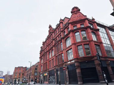 Manchester, İngiltere - 26 Ocak 2026: Uzun pencereli, köşeli, kentsel Stevenson Meydanı sokak manzaralı ve tarihi karakterli kırmızı tuğlalı Manchester binası.