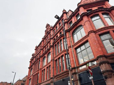Manchester, İngiltere - 26 Ocak 2026: Manchester Stevenson Meydanı 'nda geniş kemerli pencereli çok katlı bir binanın tarihi kırmızı tuğla cephesi.