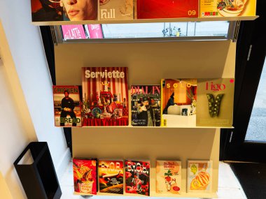 Manchester, İngiltere - 26 Ocak 2026: Manchester 'ın parlak bir köşesindeki raflarda canlı dergiler ve yemek kitapları.