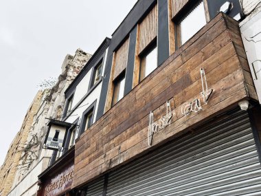 Manchester, İngiltere - 26 Ocak 2026: Manchester 'da ahşap panelli, el yazısıyla yazılmış levhası ve metal kepengi olan Gritty City Northern Quarter.