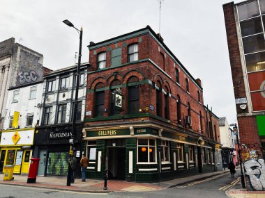 Manchester, İngiltere - 26 Ocak 2026: Yeşil kiremitli bir tuğla köşedeki Gullivers Bar 'ın yer aldığı Manchester Oldham caddesi.