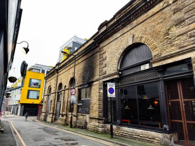 Manchester, İngiltere - 26 Ocak 2026: Manchester Coop caddesindeki kemerli camlı tuğla bina, tarihi ve modern mimarinin zıttı.