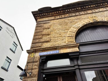 Manchester, İngiltere - 26 Ocak 2026: Manchester Swan Caddesi 'ndeki eski tuğla cephe kemerli giriş ve mağaza önü.