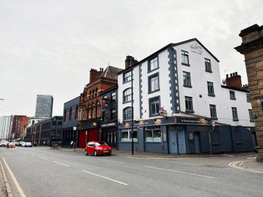 Manchester, İngiltere - 26 Ocak 2026: The Smithfield Market Tavernası, arabalar ve çevresindeki tarihi binalarla Manchester UK sokak sahnesi.