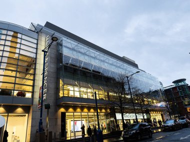 Manchester, İngiltere - 21 Ocak 2026: Manchester Marks Spencer alışveriş merkezi cam dış ve mağazalar, akşam ışıkları ve kentsel faaliyet.