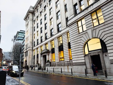 Manchester, İngiltere - 21 Ocak 2026: Büyük taştan bir binası, aydınlatılmış pencereleri ve yayaları olan Manchester Caddesi. Blackfriars Evi