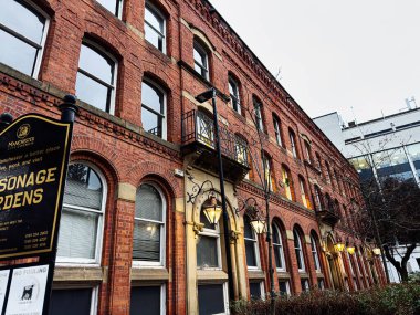 Manchester, İngiltere - 21 Ocak 2026: Manchester, İngiltere 'de kemerli pencereleri ve klasik sokak lambaları olan kırmızı tuğlalı evler.