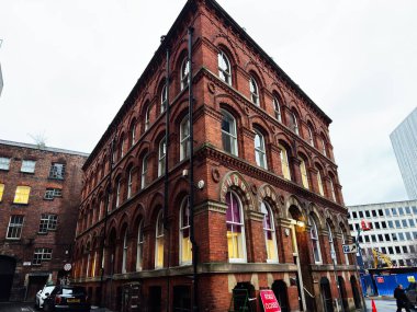 Manchester, İngiltere - 21 Ocak 2026: Manchester caddesi üzerinde kemerli camlı ve yakınındaki inşaat çalışmaları devam eden tarihi bir bina.