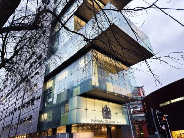 Manchester, İngiltere - 21 Ocak 2026: Camla kaplı Manchester Sivil Adalet Merkezi kentsel çevre ve ağaçlarla birlikte dış görünüm.