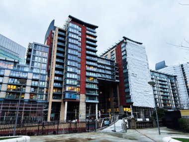 Manchester, İngiltere - 21 Ocak 2026: Manchester 'daki kentsel konut kuleleri modern mimari, cam cepheler ve etkin inşaat çalışmaları gösteriyor.