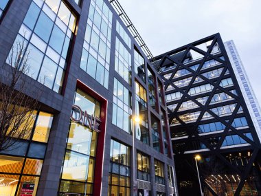 Manchester, İngiltere - 21 Ocak 2026: Manchester 'da bir New Bailey şirket binası cam duvarlar ve alacakaranlıkta kalın çapraz çelik iskelet.