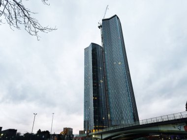 Manchester, İngiltere - 21 Ocak 2026: Manchester 'da iki uzun cam kule Vista River Gardens bulutlu bir gökyüzünün altında yükselen köprü.